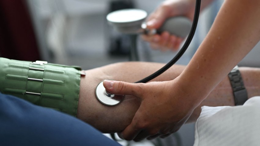 Nursing assistant 29-year Daria from Ukraine measures the blood pressure of a patient at the St. Johannes hospital in Dortmund, western Germany, on May 10, 2023.