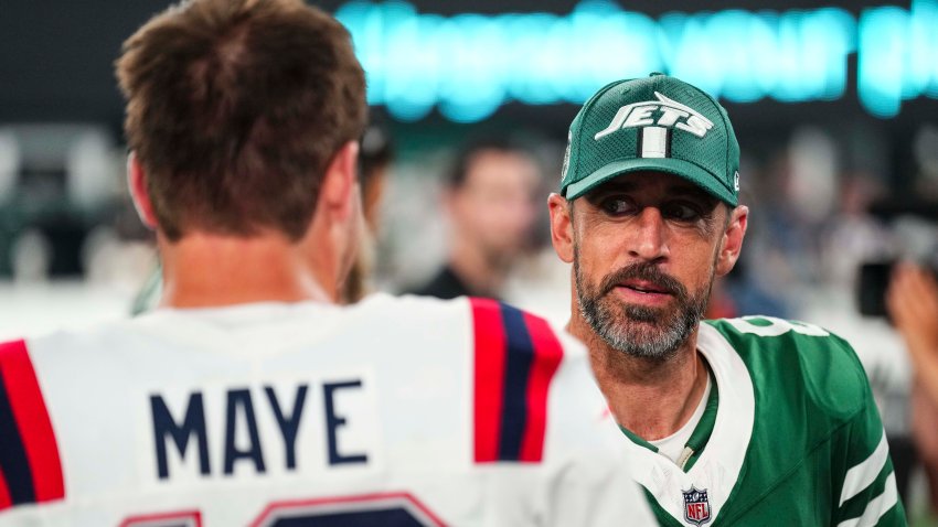 New York Jets quarterback Aaron Rodgers talks with New England Patriots quarterback Drake Maye