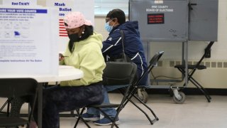 FILE – Voters fill out their ballots at a polling center during early voting, Oct. 23, 2021, in Buffalo, N.Y. (AP Photo/Joshua Bessex, File)