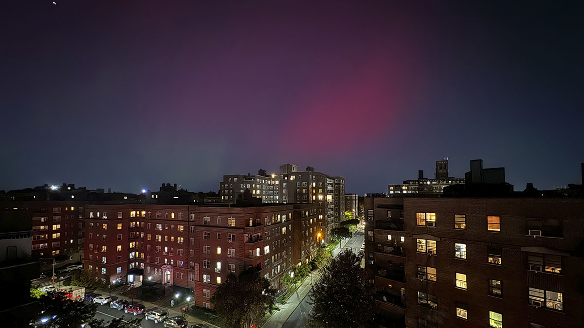 The Northern Lights shine in the night sky over homes in the New York City borough of Queens, Thursday, October 10, 2024. (AP Photo/Daniel P. Derella)