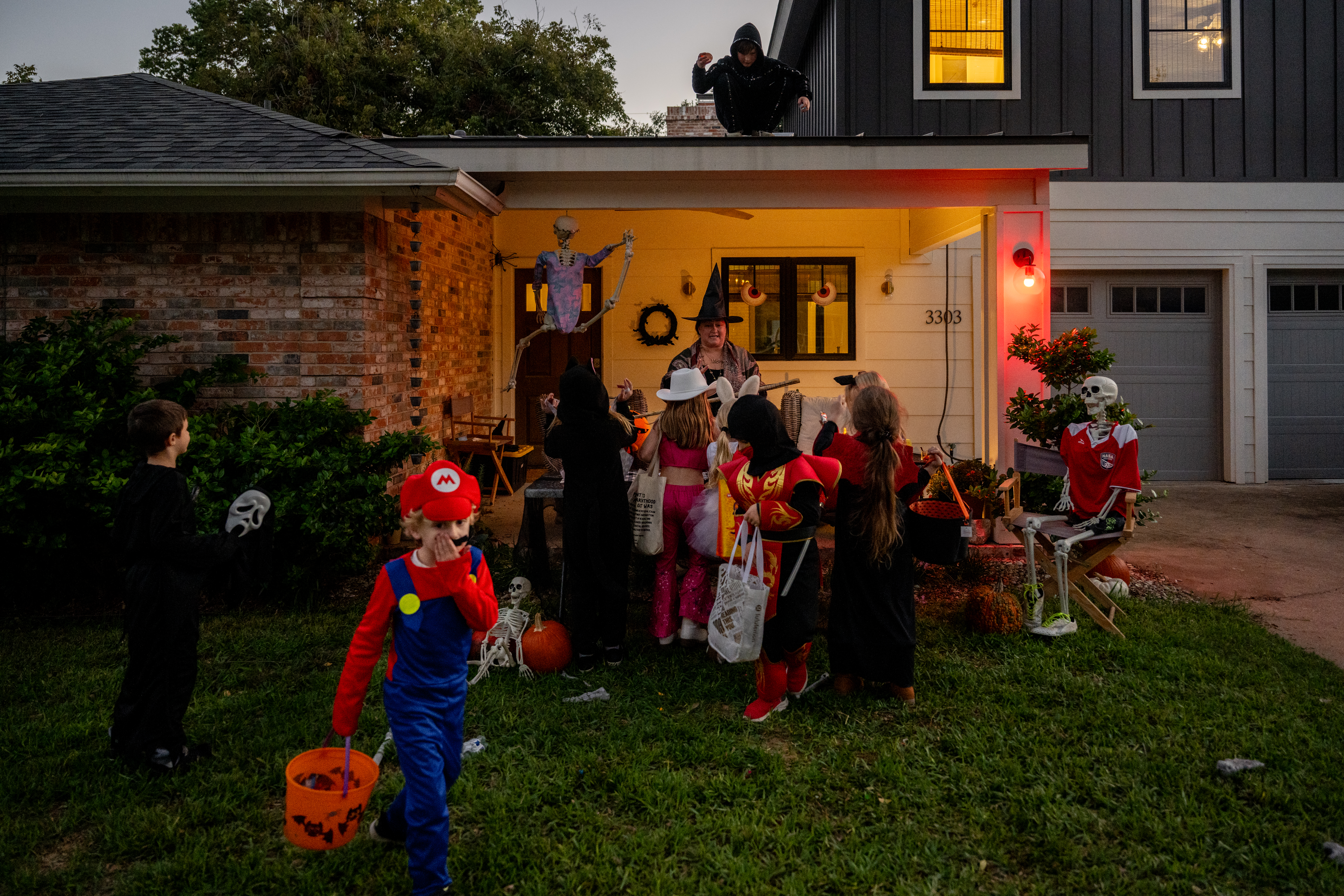 A child dressed as Mario fixes their mustache