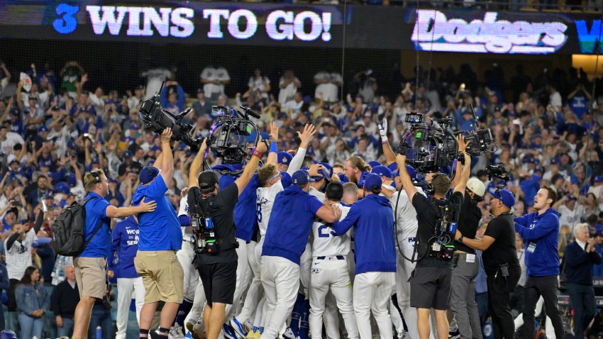 Oct 25, 2024; Los Angeles, California, USA; Los Angeles Dodgers players celebrate after first baseman Freddie Freeman (5) hit a grand slam home run in the tenth inning against the New York Yankees during game one of the 2024 MLB World Series at Dodger Stadium. Mandatory Credit: Jayne Kamin-Oncea-Imagn Images