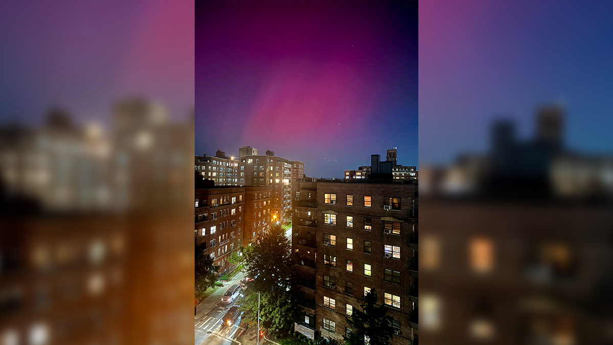 The Northern Lights shine in the night sky over homes in the New York City borough of Queens, Thursday, October 10, 2024. (AP Photo/Daniel P. Derella)