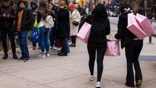 A shopper carries several bags in the Magnificent Mile shopping district of Chicago on Dec. 2, 2023.