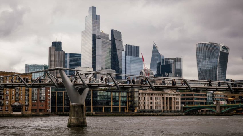 Commuters cross Millennium Bridge in view of skyscrapers on the skyline of the City of London, UK, on Tuesday, Oct. 29, 2024.