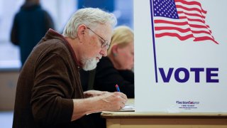 A man fills out his ballot during early voting for the US general election at a polling station at Ottawa Hills High School in Grand Rapids, Michigan, on November 3, 2024. 