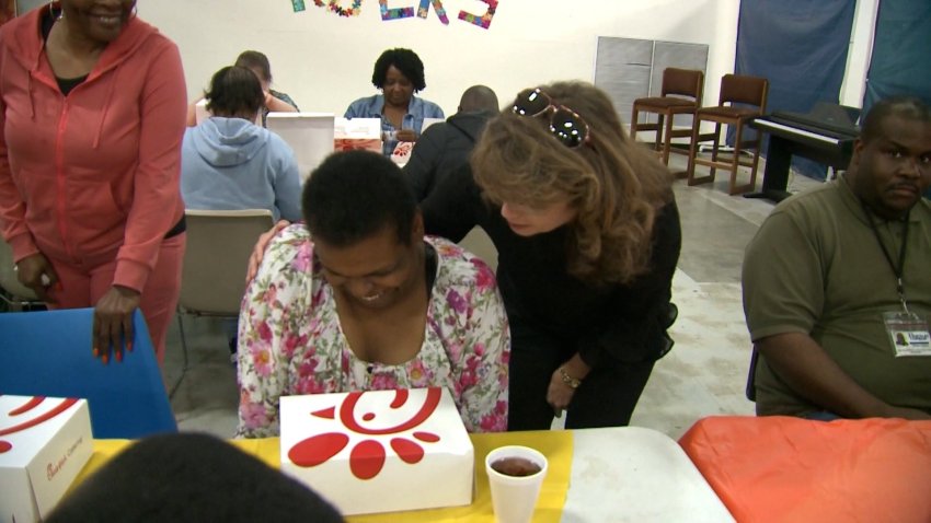 A woman hugs a woman with Chick-fil-A