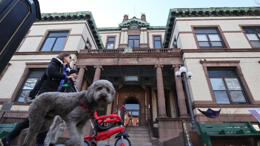 HOBOKEN NJ – MARCH 15: People walk their dog along Washington Street in front of City Hall on March 15, 2020 in Hoboken, New Jersey. The municipal government in Hoboken has taken strong measures against the community spread of the coronavirus (COVID-19) by closing, schools, playgrounds, limiting restaurants to take-out only and instituting a curfew beginning on March 16.     (Photo by Gary Hershorn/Getty Images)