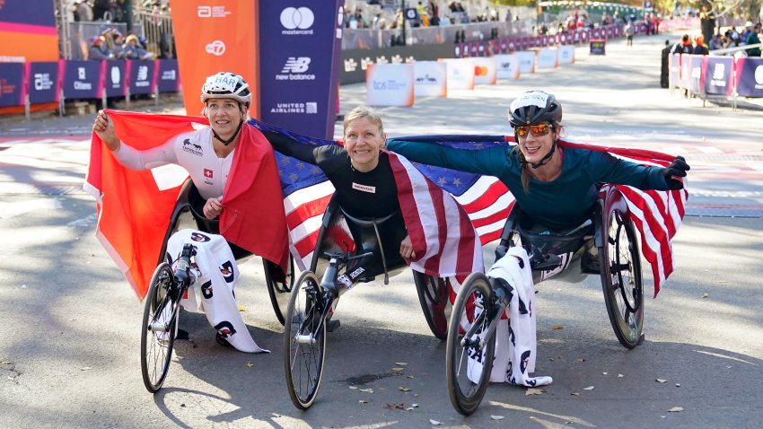 (L-R) Third place, Manuela Schar of Switzerland; first place Susannah Scaroni of the US; and second place Tatyana McFadden of the US celebrate their victories in the women's wheelchair division during New York Marathon in New York City on November 3, 2024. (Photo by TIMOTHY A. CLARY / AFP) (Photo by TIMOTHY A. CLARY/AFP via Getty Images)