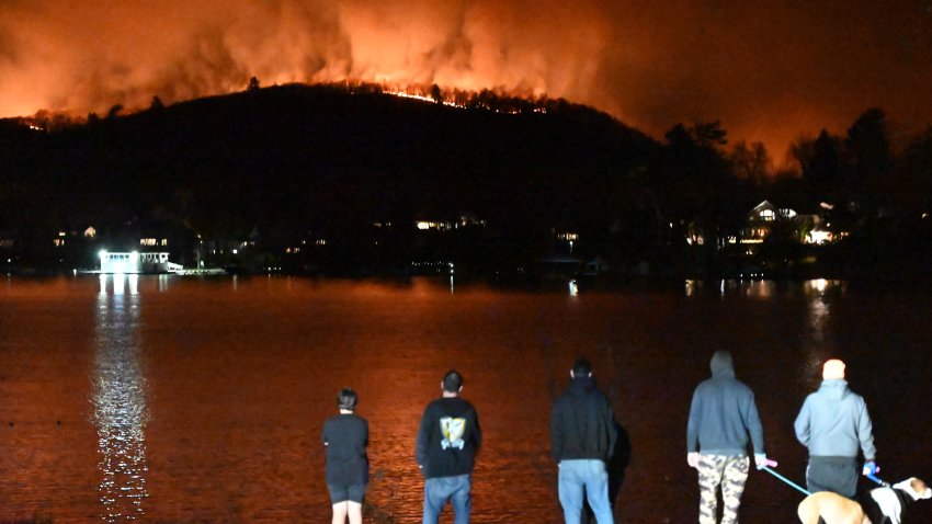 WEST MILFORD, NEW JERSEY, UNITED STATES – NOVEMBER 9: People watch as a wildfire burns and spreads on a mountain in West Milford, New Jersey, United States on November 9, 2024. Large flames have overtaken the mountain and more than 2000 acres have burned. (Photo by Kyle Mazza/Anadolu via Getty Images)