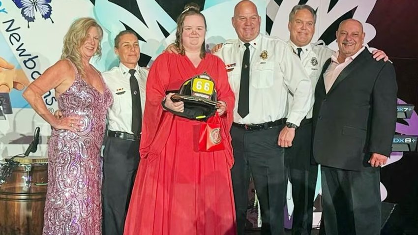 Gloria Lewis, center, who was surrendered at a fire house 21 years ago, reunites with the firefighters who found her.