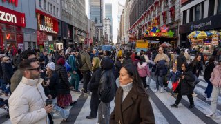 People walk at a intersection of the Herald Square shopping district on November 29, 2024 in New York City. 