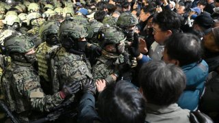 Soldiers try to enter the National Assembly building in Seoul on December 4 2024, after South Korea President Yoon Suk Yeol declared martial law. South Korea’s President Yoon Suk Yeol on December 3 declared martial law, accusing the opposition of being “anti-state forces” and saying he was acting to protect the country from “threats” posed by the North.