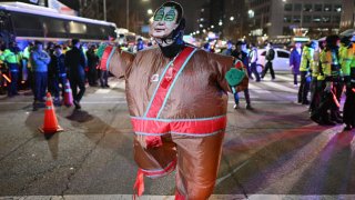 A man wearing an outfit with a face mask of South Korea’s President Yoon Suk Yeol dances outside the National Assembly in Seoul, South Korea on December 4, 2024, after Yoon declared martial law. South Korea’s President Yoon Suk Yeol on December 3 declared martial law, accusing the opposition of being “anti-state forces” and saying he was acting to protect the country from “threats” posed by the North. 