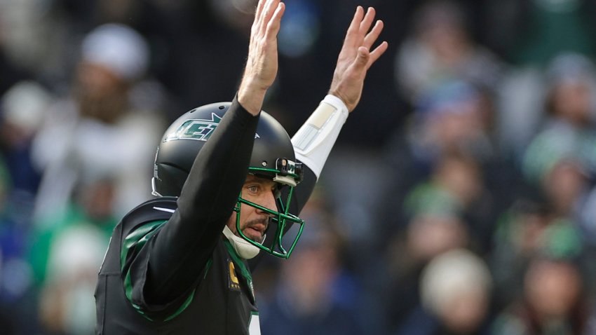 New York Jets quarterback Aaron Rodgers (8) reacts after throwing a touchdown pass against the Seattle Seahawks during the first quarter of an NFL football game, Sunday, Dec. 1, 2024, in East Rutherford, N.J. (AP Photo/Adam Hunger)