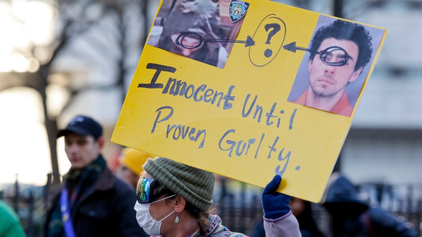 A demonstrator holds up a sign while waiting for the arrival of Luigi Mangione for his arraignment at Manhattan Criminal Court, Monday, Dec. 23, 2024, in New York. (AP Photo/Stefan Jeremiah)