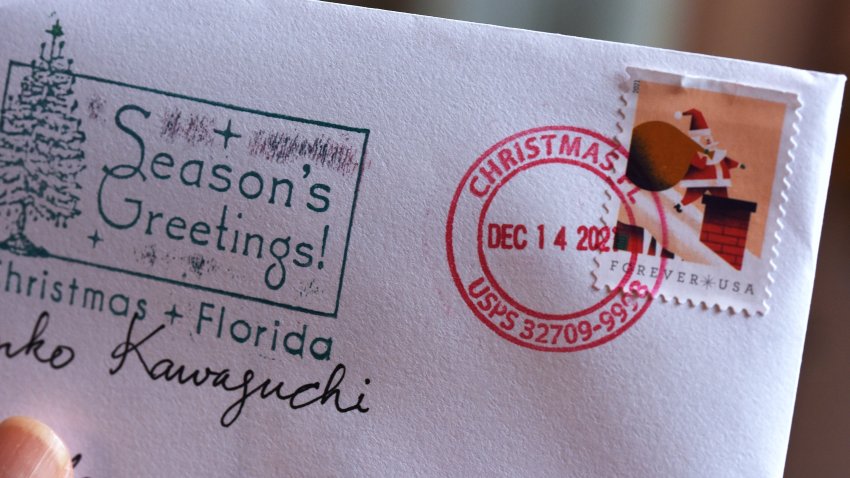 ORLANDO, FLORIDA, UNITED STATES – 2021/12/17: A Christmas card is seen in Orlando, bearing a postmark from the nearby Christmas, Florida post office.
Each year, thousands of people bring their holiday greeting cards to the tiny post office in Christmas, Florida to have them stamped with the unique Christmas postmark. Postal customers can also use rubber stamps provided by the post office to adorn their envelopes with seasonal designs and greetings. (Photo by Paul Hennessy/SOPA Images/LightRocket via Getty Images)