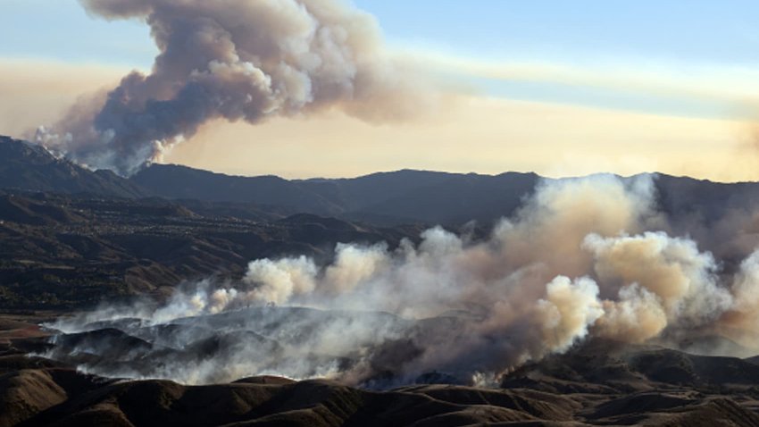 In this aerial view taken from a helicopter, the Kenneth fire (below) approaches homes while the back side of the Palisade fire (above) continues to burn Los Angeles county, California on January 9, 2025. 