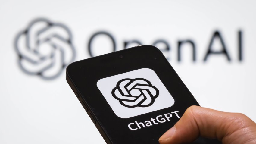 person holds a smartphone displaying the ChatGPT logo