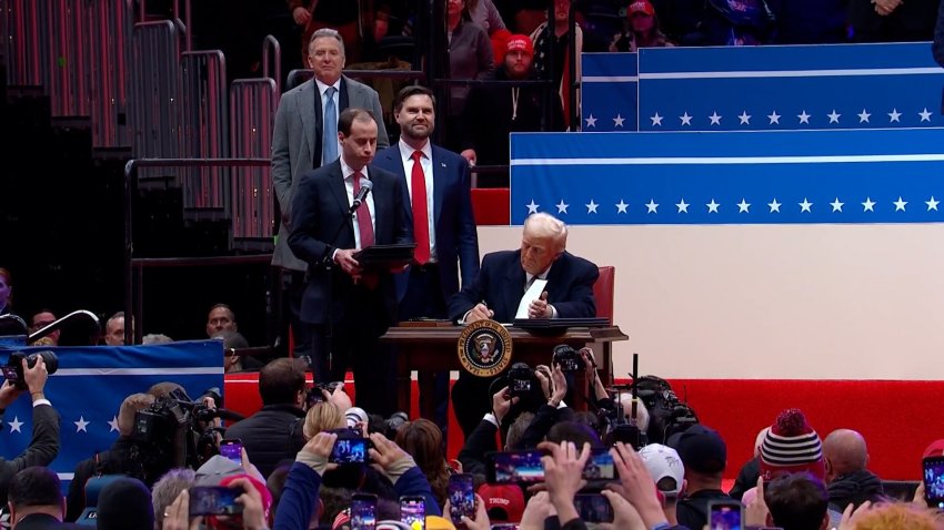 Donald Trump signs executive order at rally