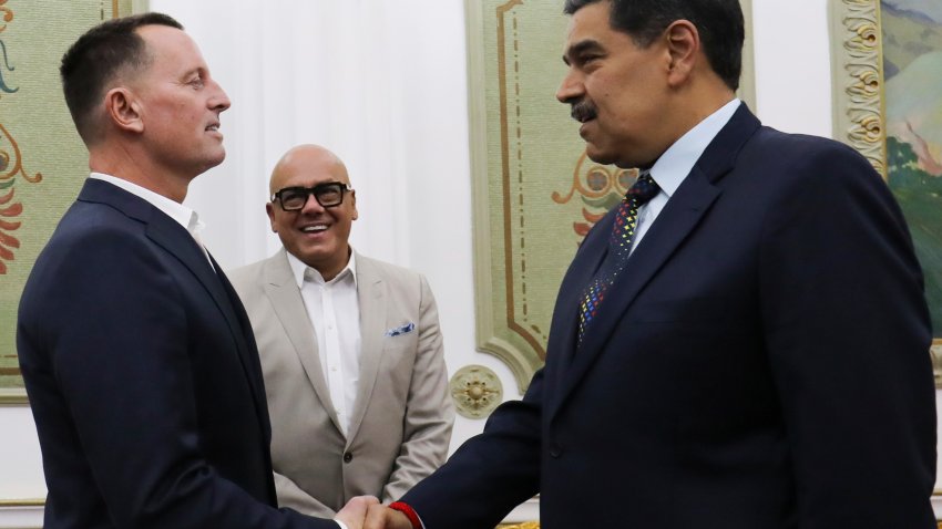 This photo released by Venezuela's presidential press office shows Venezuelan President Nicolas Maduro, right, shaking hands with Richard Grenell,