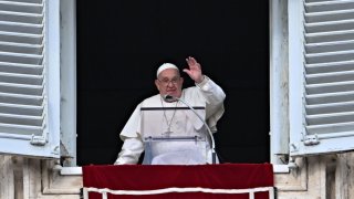 Pope Francis waves to the crowd from the window of the Apostolic Palace overlooking St Peter's Square during the Epiphany Angelus prayer, in the Vatican, on January 6, 2025.