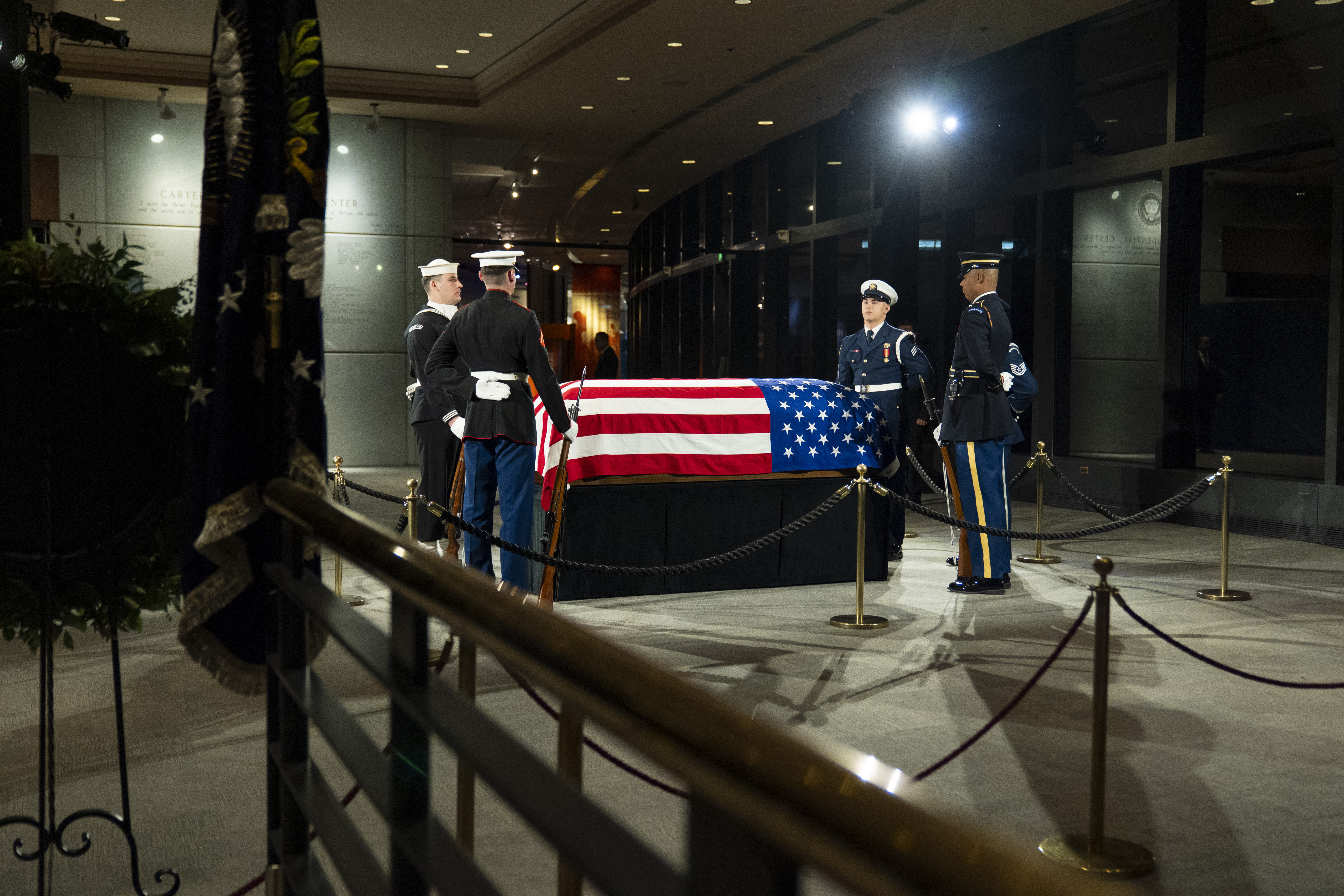 The joint services military honor guard stand around the casket of former President Jimmy Carter at the Jimmy Carter Presidential Library and Museum.