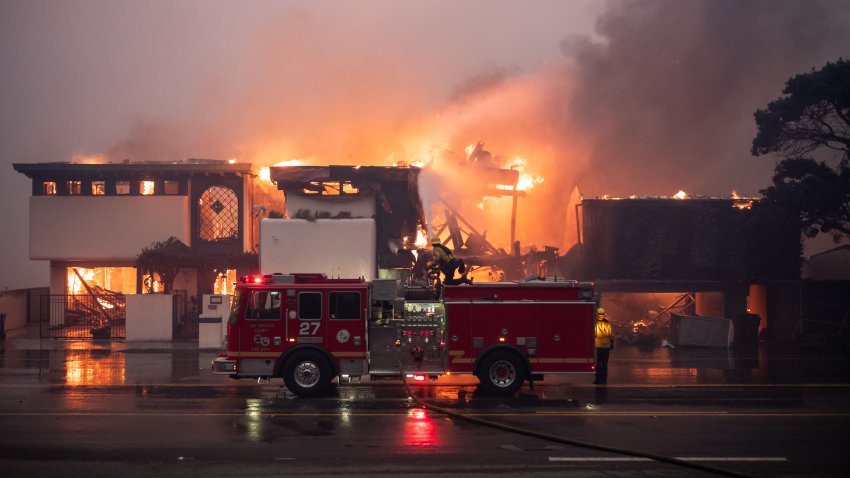 Firefighters continue to battle wind and fire as homes go up in flames in Malibu along Pacific Coast Highway near Carbon Canyon Road in the Palisades Fire on Wednesday, January 8, 2025.