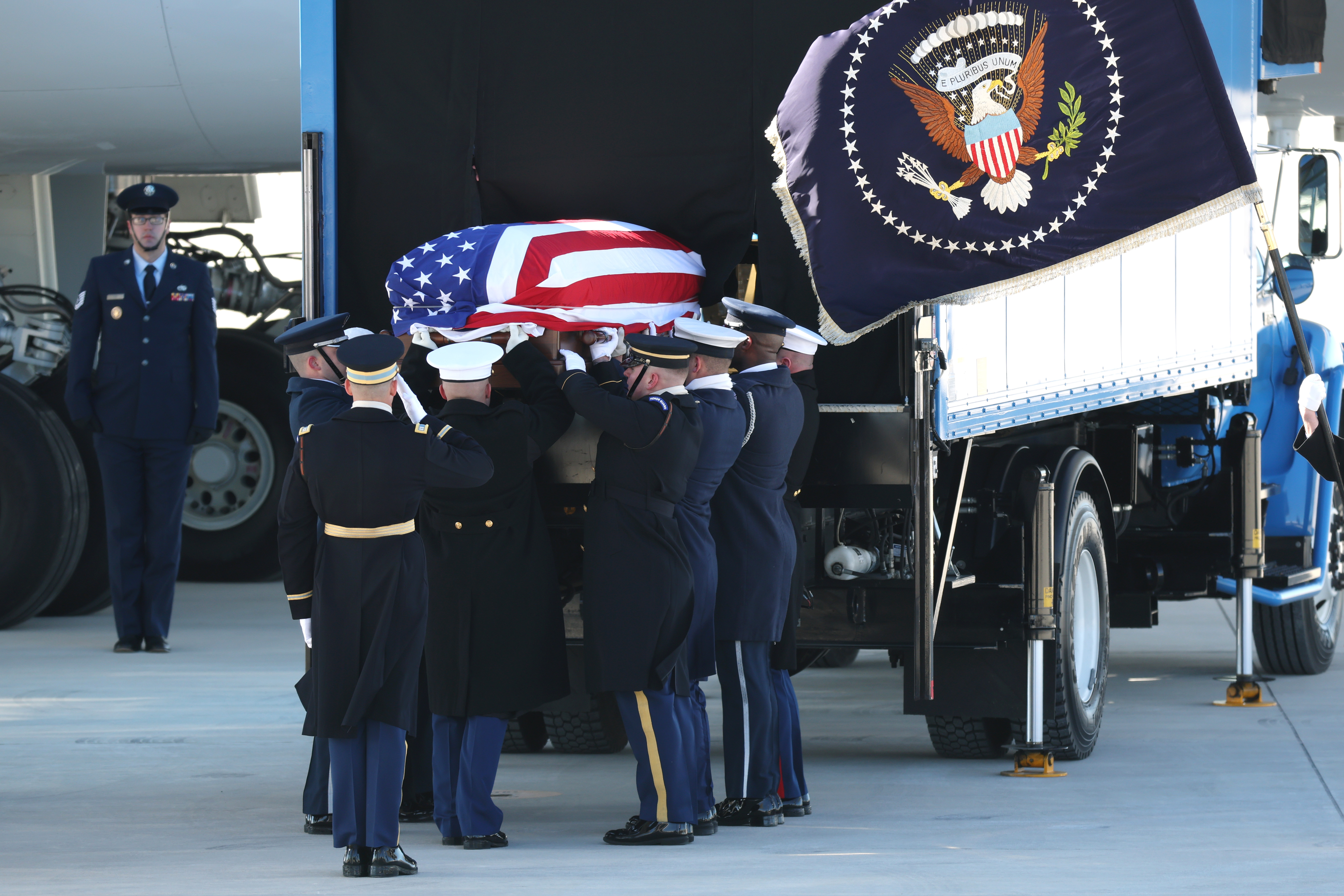 U.S. Military Body Bearers place the flag-draped casket in Special Air Mission 39 on its way to Washington, DC at Dobbins Air Reserve Base.