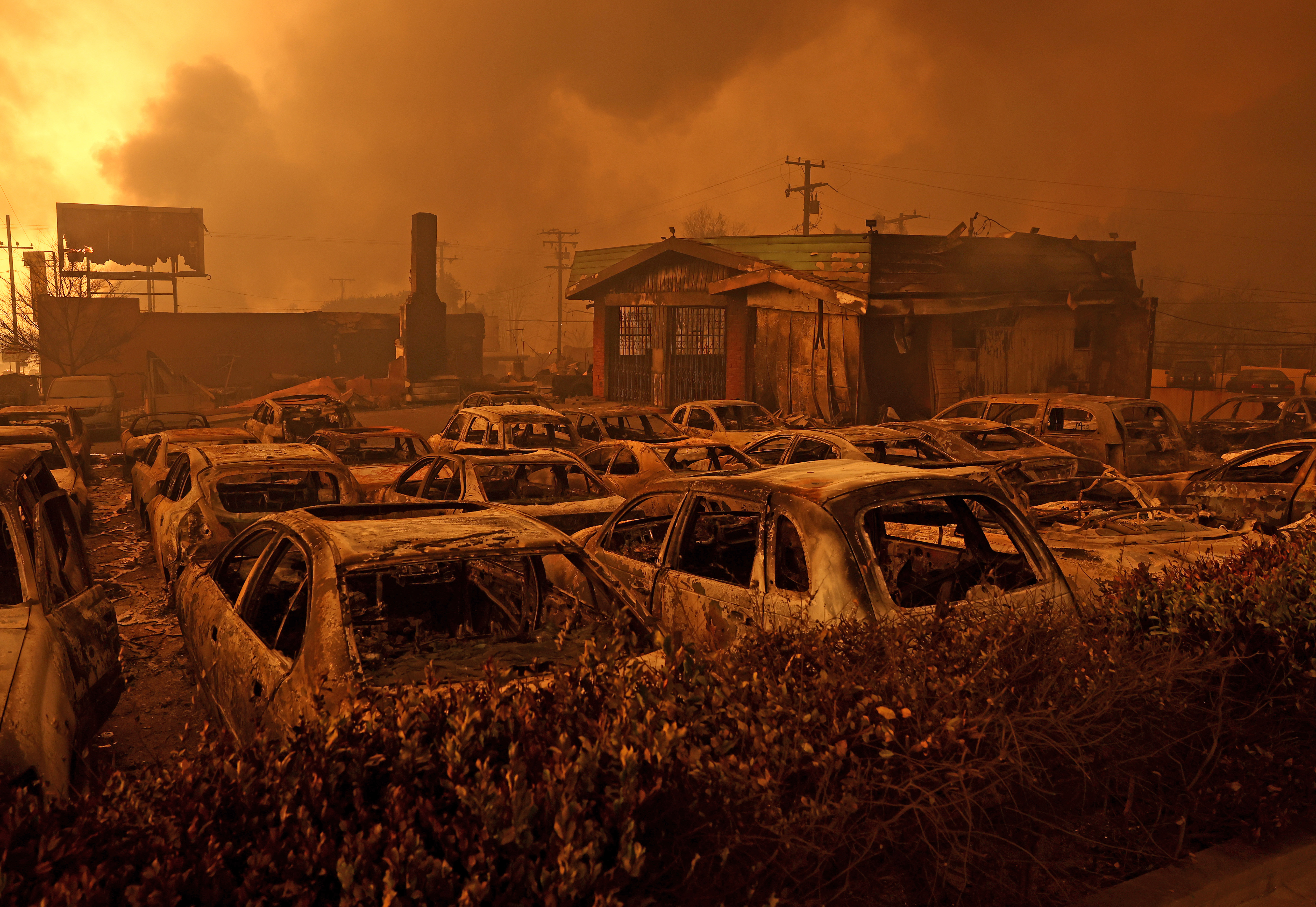 Cars destroyed by the Eaton Fire sit in the parking area of a burned auto shop on Jan. 08, 2025 in Altadena.