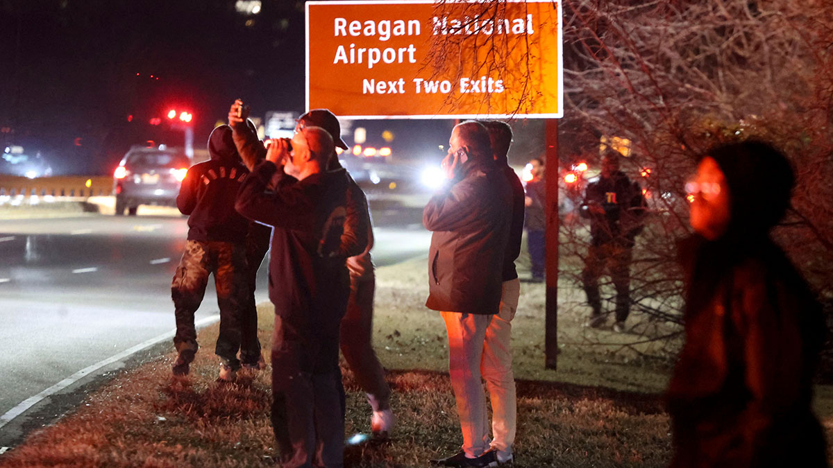 Onlookers watch as emergency crews respond to the crash site near the Potomac River after a passenger jet collided with a helicopter while landing at Ronald Reagan National Airport (DCA) in Arlington, Virginia, US, on Wednesday, Jan. 29, 2025. A PSA Airlines Bombardier CRJ700 regional jet collided in midair with a military helicopter Sikorsky H-60 while on approach to Runway 33 at Reagan Washington National Airport around 9 p.m. local time, according to a FAA statement. (Photo: Alex Wroblewski/Bloomberg via Getty Images)
