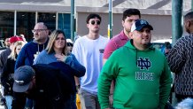 Jan 1, 2025; New Orleans, LA, USA;  Notre Dame Fighting Irish fans walk past the scene of a mass casualty incident on Canal and Bourbon Street. Mandatory Credit: Stephen Lew-Imagn Images