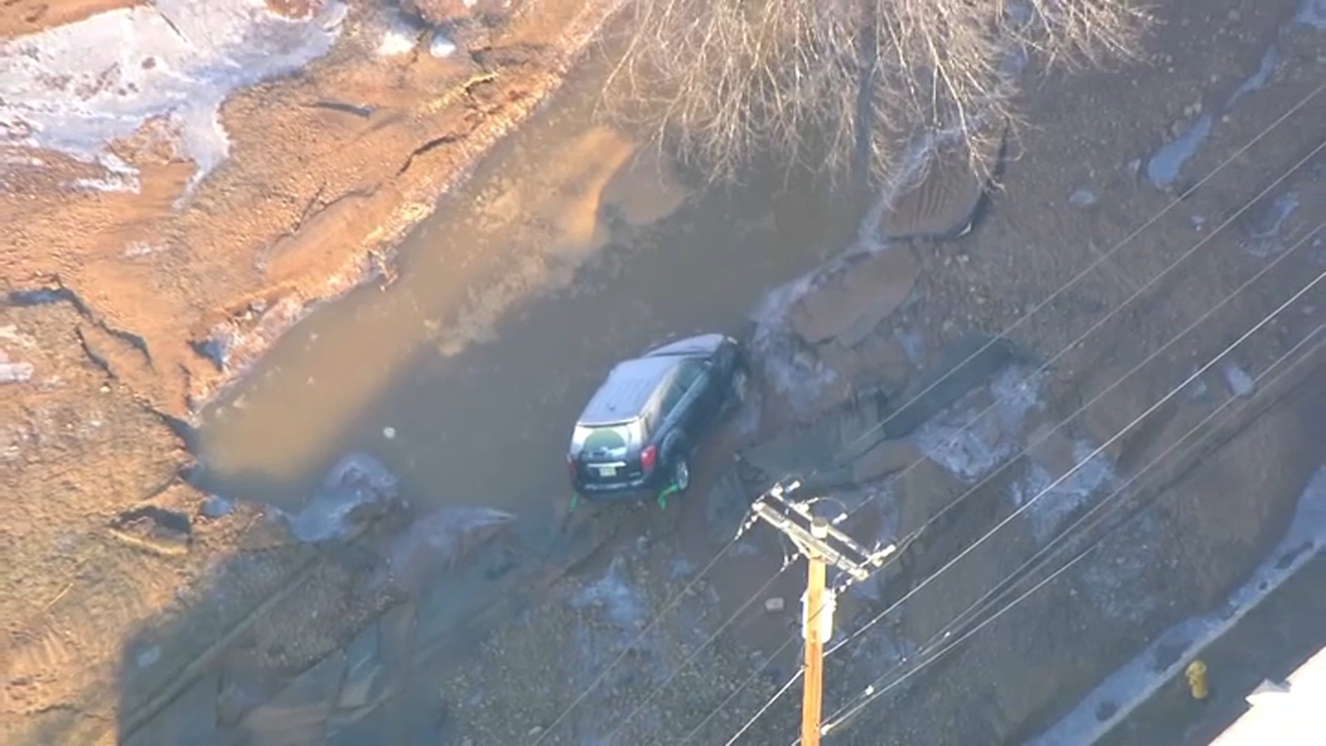 SUV partially swallowed by sinkhole after NJ water primary break SUV partially swallowed by sinkhole after NJ water primary break