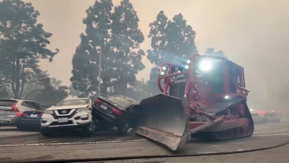 A fire department bulldozer moves abandoned cars in Pacific Palisades on Jan. 7, 2025.