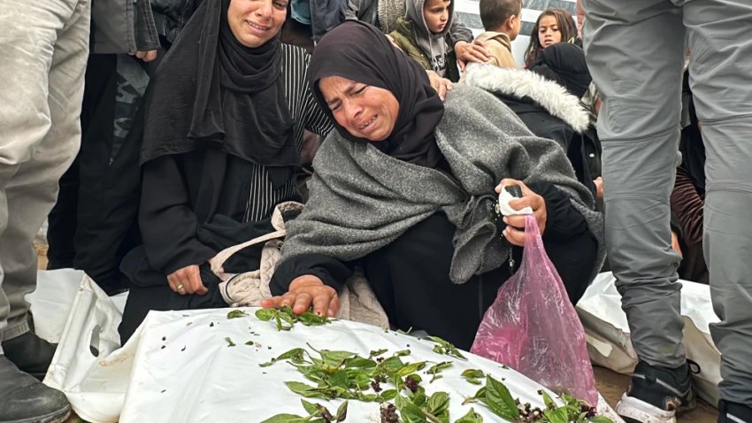 A grieving woman spreads leaves over a body bag outside Nasser Hospital in Khan Younis, southern Gaza, on Thursday.