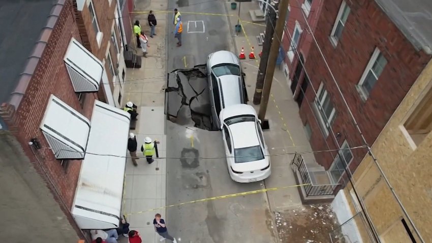 An aerial view of a giant sinkhole in a street.