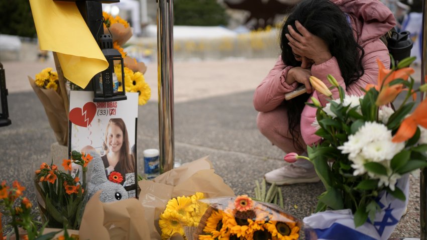 A woman mourns in a memorial for deceased hostages Shiri Bibas, her two children