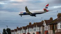 British Airways Boeing 787-8 Dreamliner aircraft spotted flying on final approach over the roofs of the houses of Myrtle avenue for landing at London Heathrow Airport LHR in the UK.