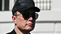 Tesla CEO Elon Musk looks on as US President Donald Trump speaks to the press as they stand next to a Tesla vehicle on the South Portico of the White House on March 11, 2025 in Washington, DC. 