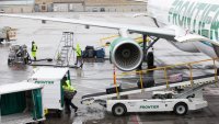 A ground operations employee unloads baggage from a Frontier Airlines Inc. plane on the tarmac at Denver International Airport (DIA) in Denver, Colorado.