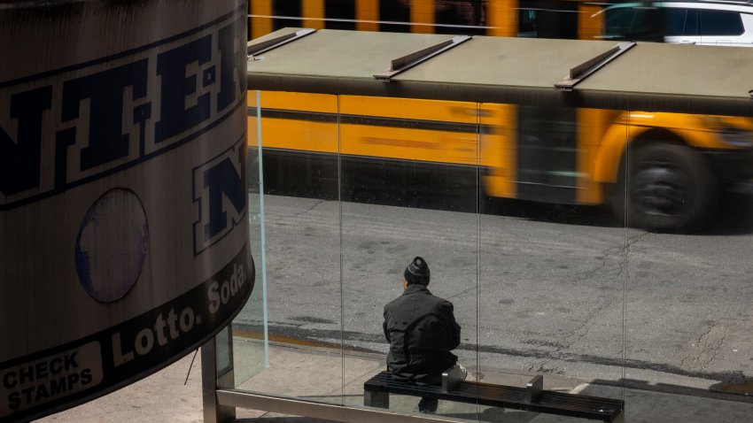 A person waits at a bus stop in the Brooklyn borough on March 25, 2025 in New York City. 