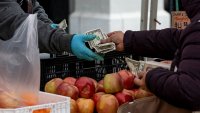 A shopper holds US banknotes while paying for produce at the farmer’s market in San Francisco, California, US, on Thursday, March 27, 2025. 