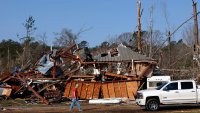 Residents look for personal belongings in the damage after