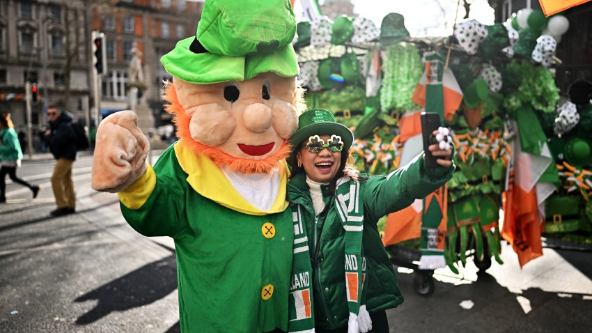 DUBLIN, IRELAND – MARCH 17: A woman poses for a photo with a man in costume during the St. Patrick’s Day parade on March 17, 2024 in Dublin, Ireland. This year’s theme of the parade is Spréach, the Irish word for Spark,  which is said to represent the unique essence of Ireland and its people. The parade starts at midday on Parnell Square North down then moves to O’Connell Street and crosses the River Liffey. (Photo by Charles McQuillan/Getty Images)