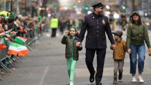 An NYPD officer (2nd L) walks hand in hand with a young boy and a young girl during the 2025 New York City St. Patrick's Day Parade on March 17, 2025 in New York City. (Photo by Michael Loccisano/Getty Images)