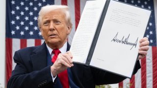 President Donald Trump holds a signed executive order after delivering remarks on reciprocal tariffs during an event in the Rose Garden on April 2, 2025.