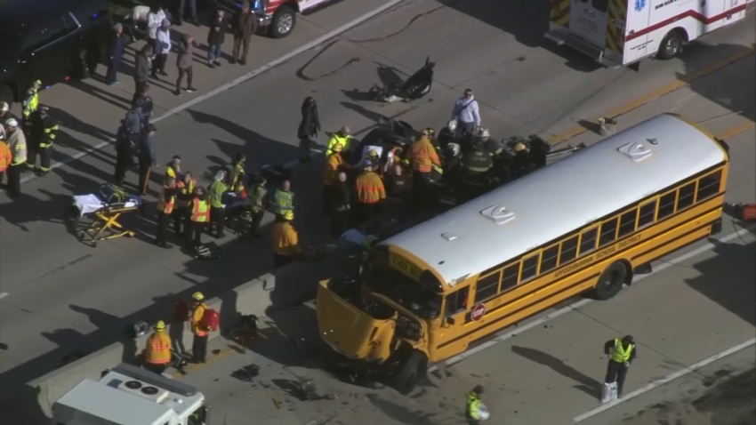 Crashed school bus and car surrounded by rescue crews.