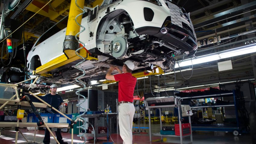 An employee installs parts on the undercarriage of a Mercedes-Benz GLS-Class SUV at the Mercedes-Benz US International factory in Vance, Alabama on June 8, 2017. 