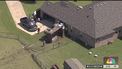 Dump truck crashes into North Tarrant home after car blows tire