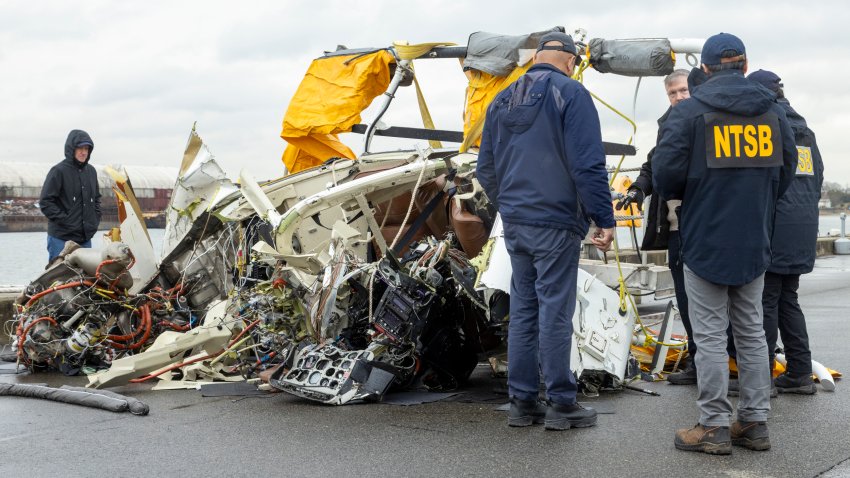 In this image released by the National Transportation Safety Board, an NTSB team surveys the wreckage, April 11, 2025, in Jersey City, N.J., recovered from the Bell 206L-4 helicopter that crashed into Hudson River on April 10,  between New York City and New Jersey.